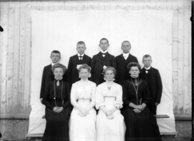 Gruppebilde 1910  Ytre Enebakk
Konfirmasjonsbilde 4 jenter, 5 gutter. Utendørs. To jenter i hvite kjoler, de andre i svart.
Nøkkelord: gruppebilde;konfirmasjon;ytre;gutter;jenter;kjoler;dress;pyntet;utendørs;smykker