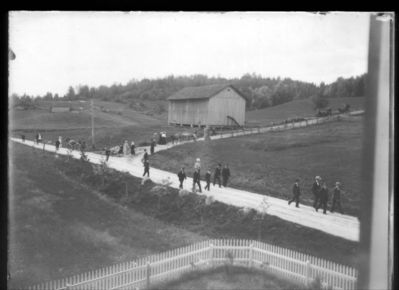 Landskap  1900 - 10 Ytre Enebakk
Folk på vei fra Mari kirke ned kirkebakken. Bilde tatt fra Ytre Enebakk skole.
Nøkkelord: landskap;mari;kirke;kirkebakken;ytre;folk;pyntet;menn;kvinner;jorde;pyntet;dress;kjole;gjerde;bjerkely;strøm;strømstolpe