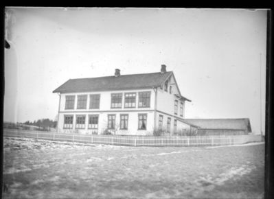 Bygning 1900 - 10  Ytre Enebakk skole
Ytre Enebakk skole sett fra hagesiden. Vinter/tidlig vår.
Nøkkelord: bygning;skole;ytre;vinter;vår;hageside;hage;hus;låve;gjerde;tre;trær;jorde