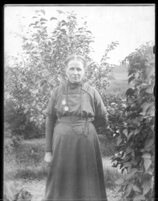 Portrett 1900 - 10
Stående kvinne, utendørs, sommer.
Nøkkelord: portrett;kvinne;pyntet;kjole;smykke;smykker;utendørs;sommer;tre;trær;dame;stående