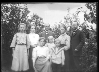 Gruppebilde senere enn 1908.  Ytre Enebakk
Tre kvinner, to menn og tre barn. Helt til høyre Johan Lorentsen, de tre yngste barna hans, Karen, Thorleif og Thrine. (Kona døde i 1907, bildet sannsynligvis tatt etter dette.)
Nøkkelord: gruppebilde;menn;kvinner;barn;ytre