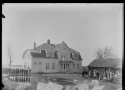 Bygning 1900 - 15,  Ytre Enebakk
Brevig gård, hovedbygningen set fra gårdstunet. Barn og arbeidere oppstilt foran huset. Uskarpt.
Nøkkelord: bygning;hovedbygning;ytre;brevig