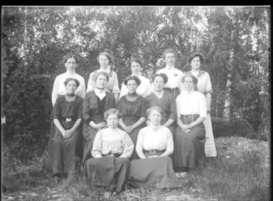 Gruppebilde  1910 - 15
Tolv kvinner oppstilt utendørs. Sommer.
Nøkkelord: gruppe;kvinner;dame