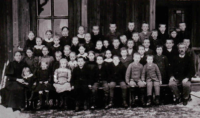 Nøkkelord: elever;jenter;gutter;utendørs;pyntet;dress;kjole;skole;klassebilde;klasse;skolebilde;unge;smykker;voksne;lærer;lærere;småbarn;fabrikkskolen;fabrikk