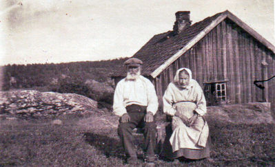 Nøkkelord: mann;dame;gammel;ekteparr;johan;treni;fredriksen;ytre;enebakk;ytreenebakk;slora;hus;landskap;gårdsbruk;forkle;kjole