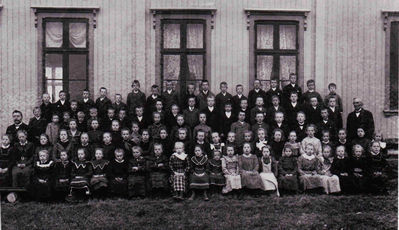 Nøkkelord: elever;jenter;gutter;lærer;utendørs;pyntet;dress;kjole;skole;klassebilde;klasse;skolebilde;unger;unge;barn;lærere;strandenskole;stranden;flateby